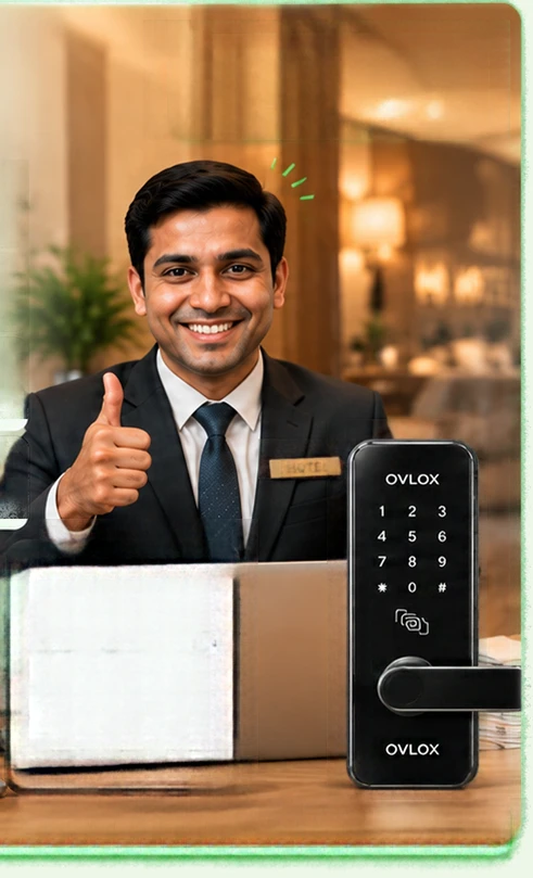 A hotel manager giving a thumbs up at a reception desk, with the Ovlox India HMS dashboard open on a laptop showing rooms, check-ins, check-outs and revenue, and an Ovlox India smart hotel lock beside it.